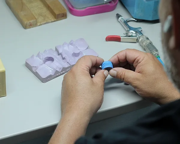 Mãos a retirar um modelo de cera de um molde